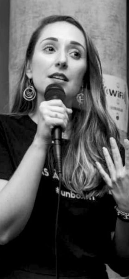 Rafaella Andrade falando ao microfone em um evento